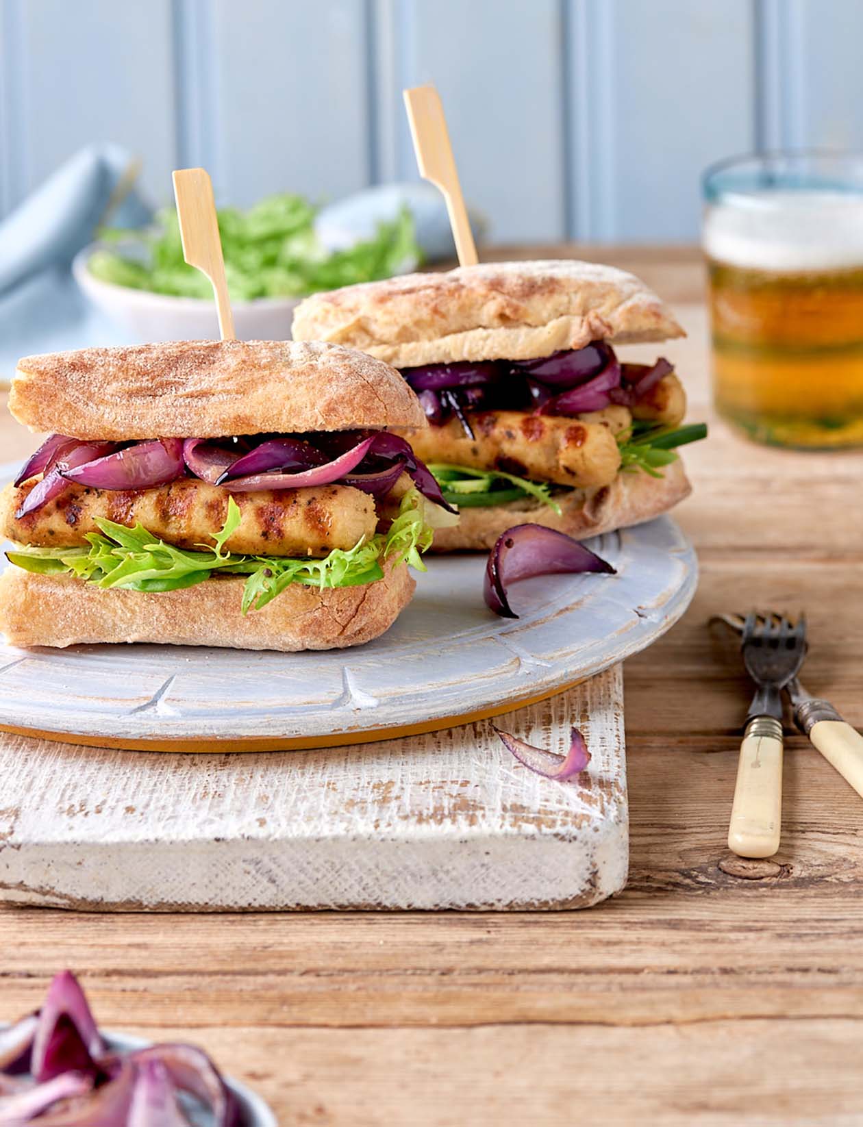 Sponsored: BBQ Little Willies Sausage burgers with caramelised onions | Sainsbury`s Magazine