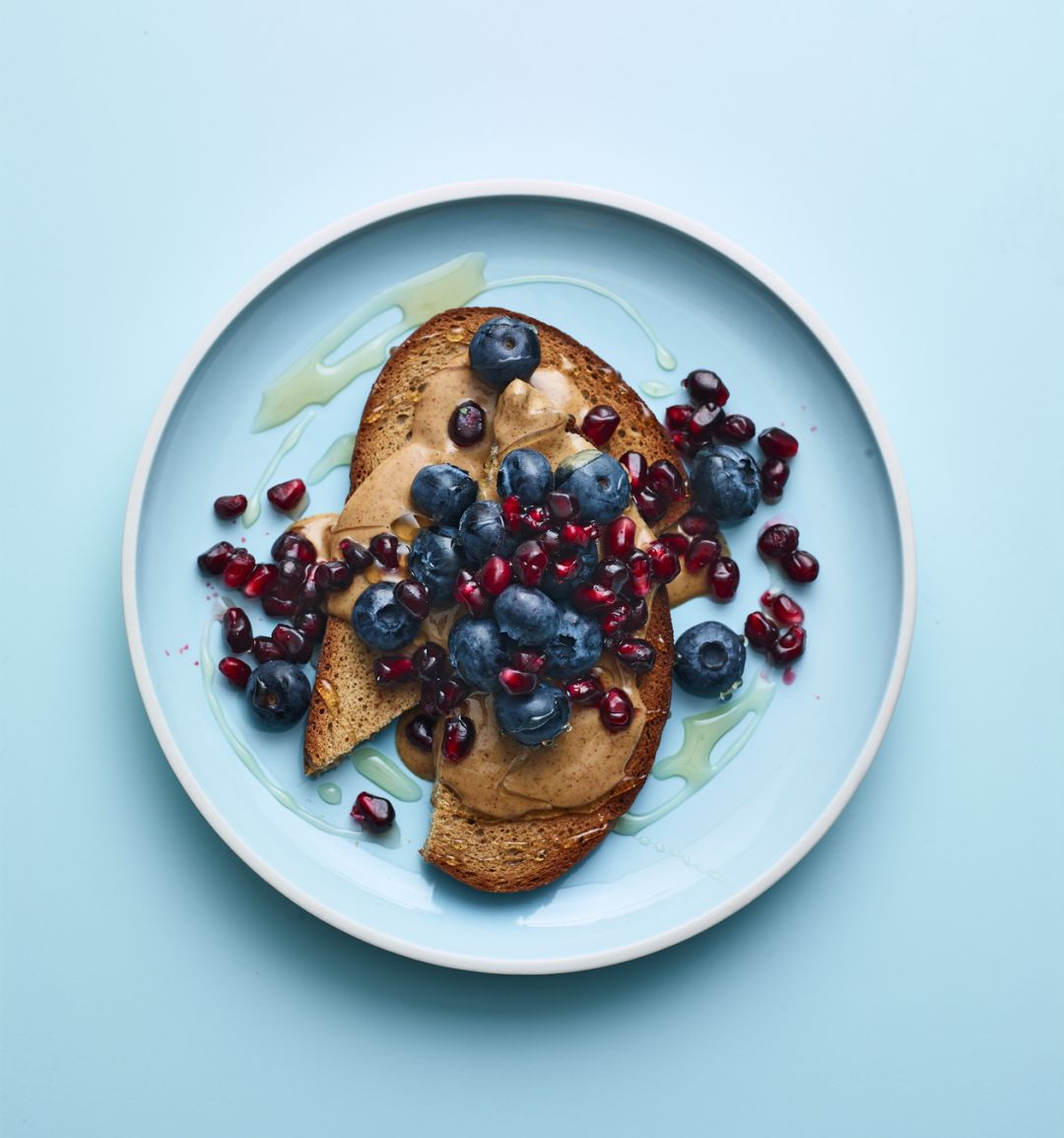 Nut butter on toast with blueberries and pomegranate