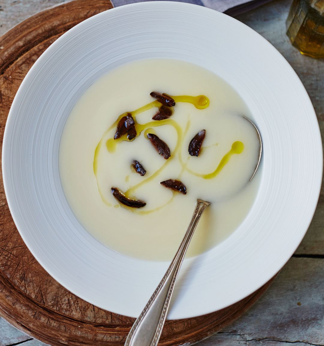 Velvety potato soup with black olives and truffle oil
