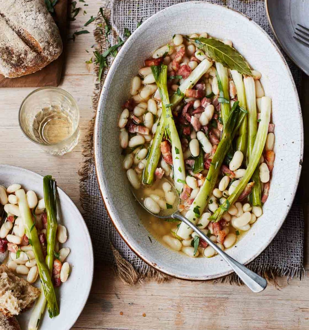 Slow-cooked spring onions with cannellini, bacon and tarragon 