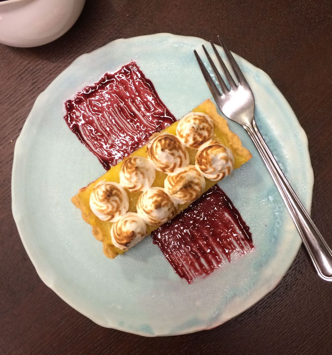 Lemon meringue tart with blackberry coulis