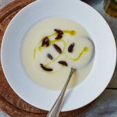 Velvety potato soup with black olives and truffle oil
