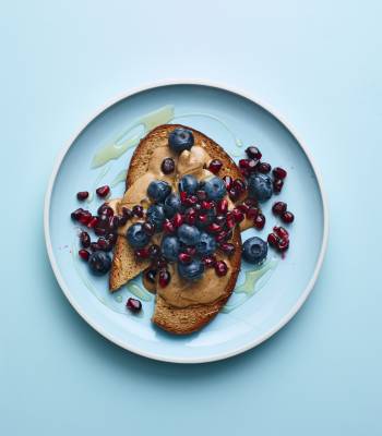 Nut butter on toast with blueberries and pomegranate