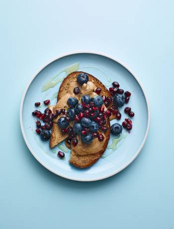 Nut butter on toast with blueberries and pomegranate