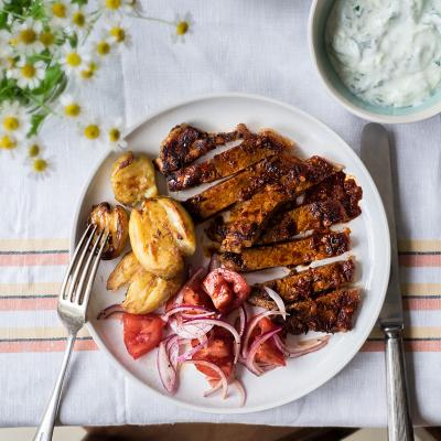 Harissa steak with tomato salad, tzatziki and crushed new potatoes