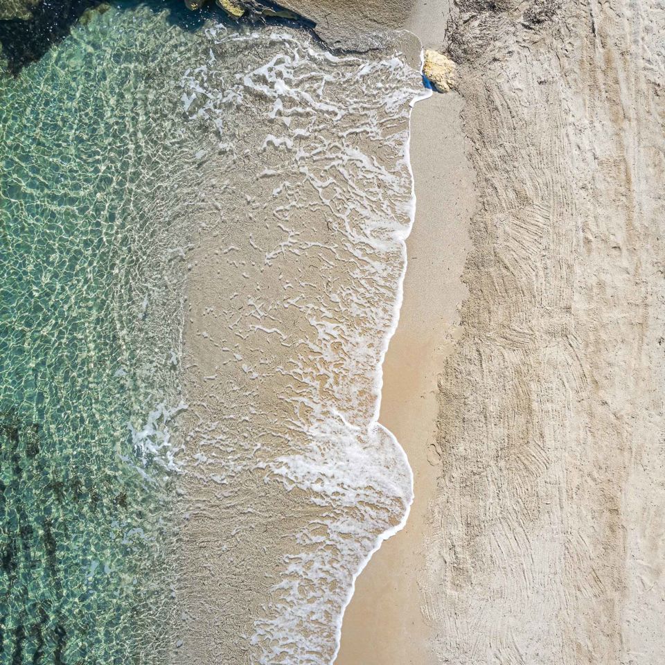 The sand and pebble beach at Grecotel LUXME White