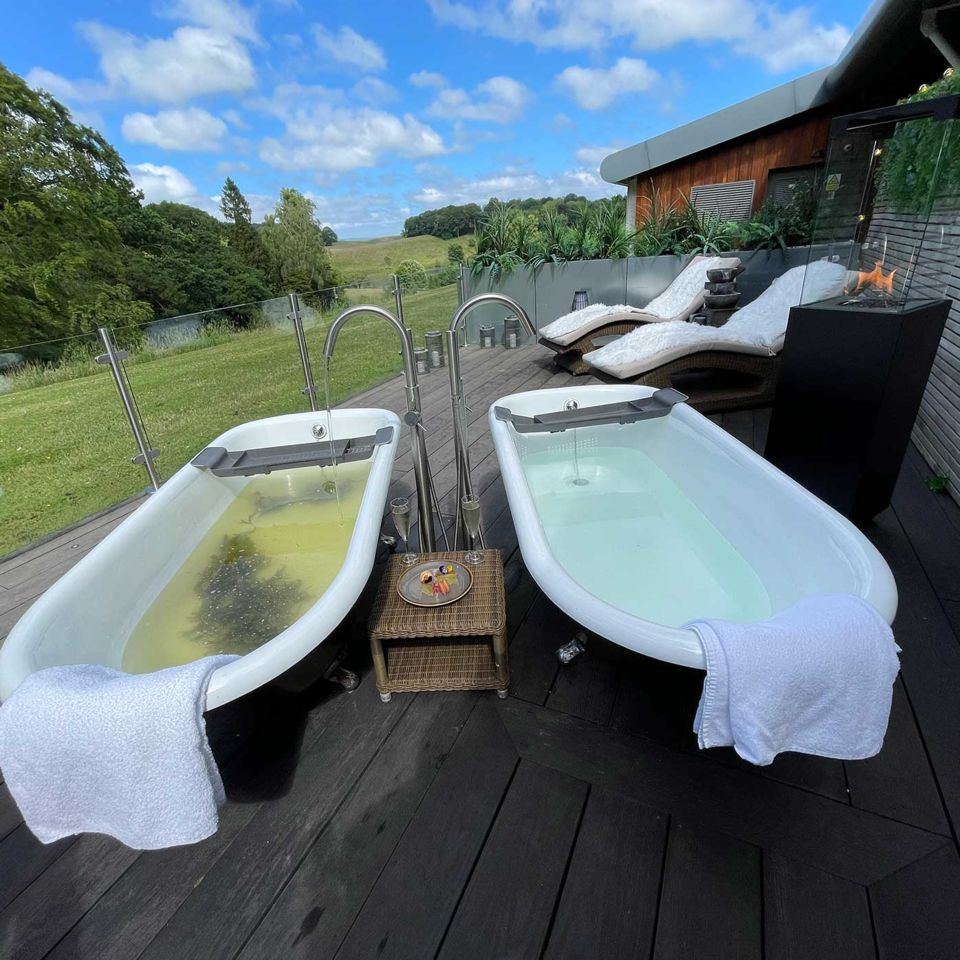 The outdoor spa experience overlooking sheep filled fields