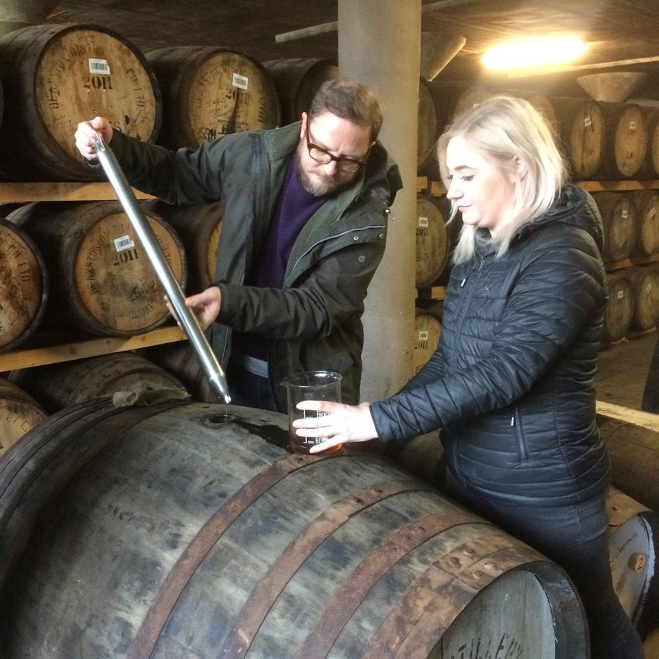 Rufus siphons whisky from a cask at Deanston Distillery