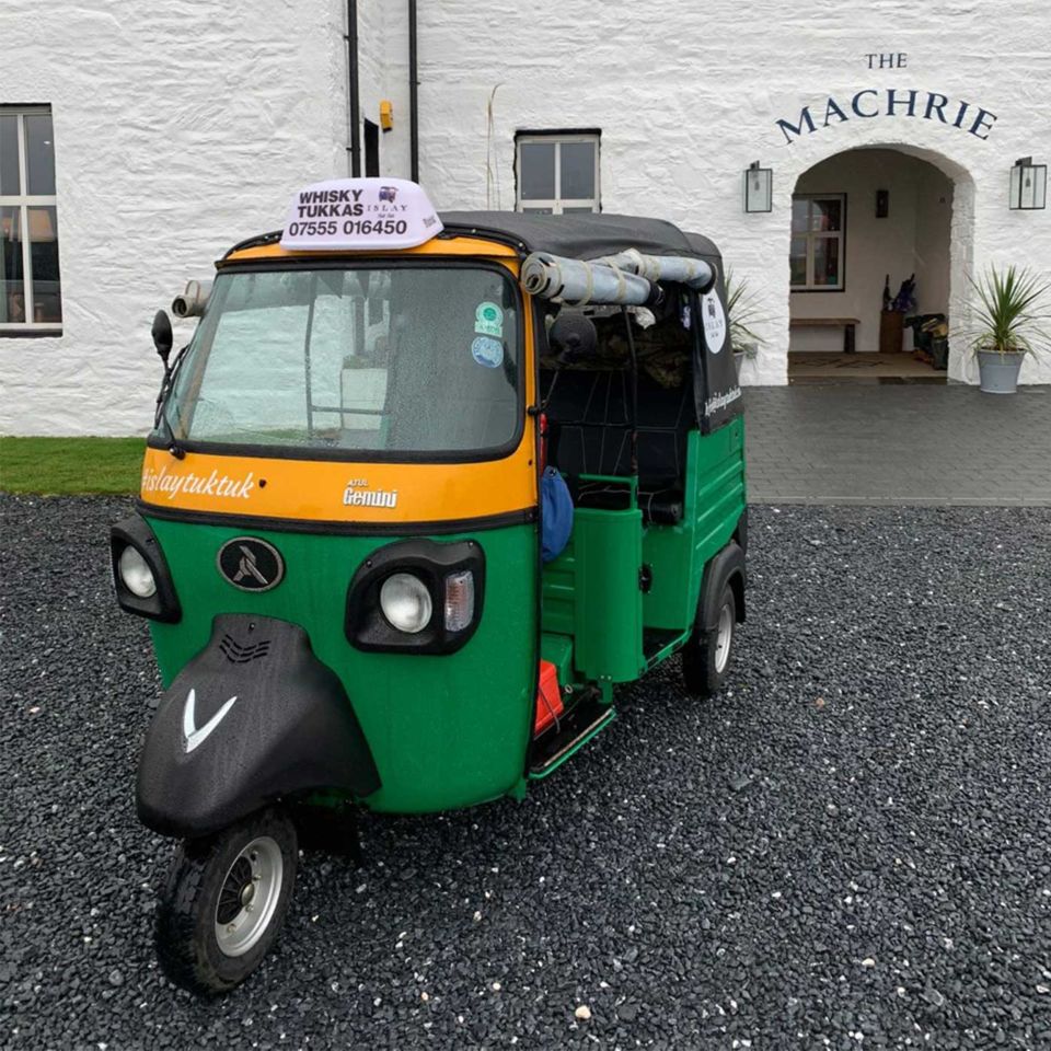 A bright green Tuk Tuk outside The Machrie