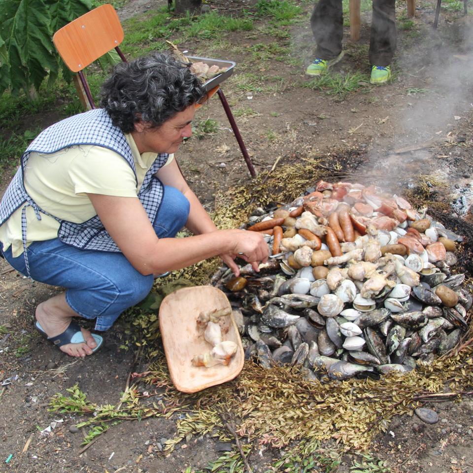 Preparing the curanto feast in a fire pit